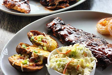 Baby back BBQ ribs, loaded potato skins and homemade coleslaw catered by Collective Brands Catering for birthday parties and anniversaries.