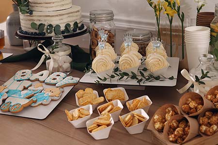 Table of sweets, treats, cake, popcorn, and cracker catered for baby shower by Collective Brands Catering in Pennsylvania.