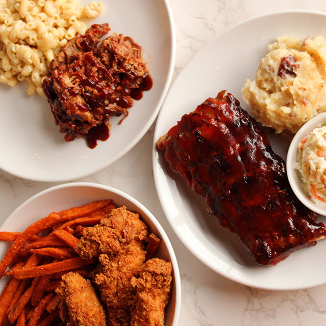 Smoked BBQ ribs, pulled pork and homemade mac and cheese served beside sweet potato fries and broasted fried chicken from Pennsylvania caterer Collective Brands Catering