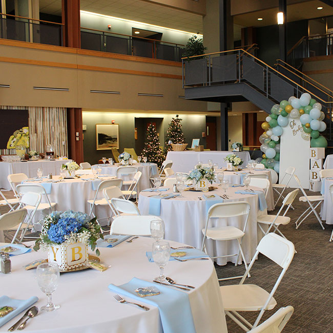 Table settings and floor layout in an open concept venue with sweeping staircases and floor-to-ceiling windows